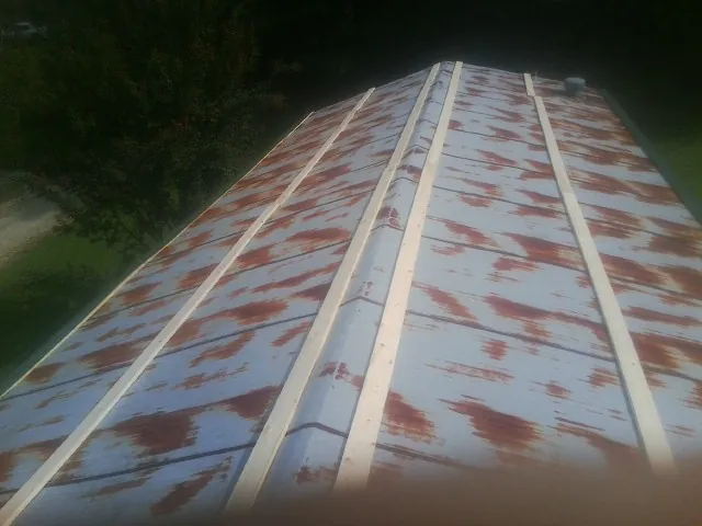 Rusted metal roof panels with new wood purlins before replacement — Storm Damage Roof Repair in Bogart by Roofing Brothers