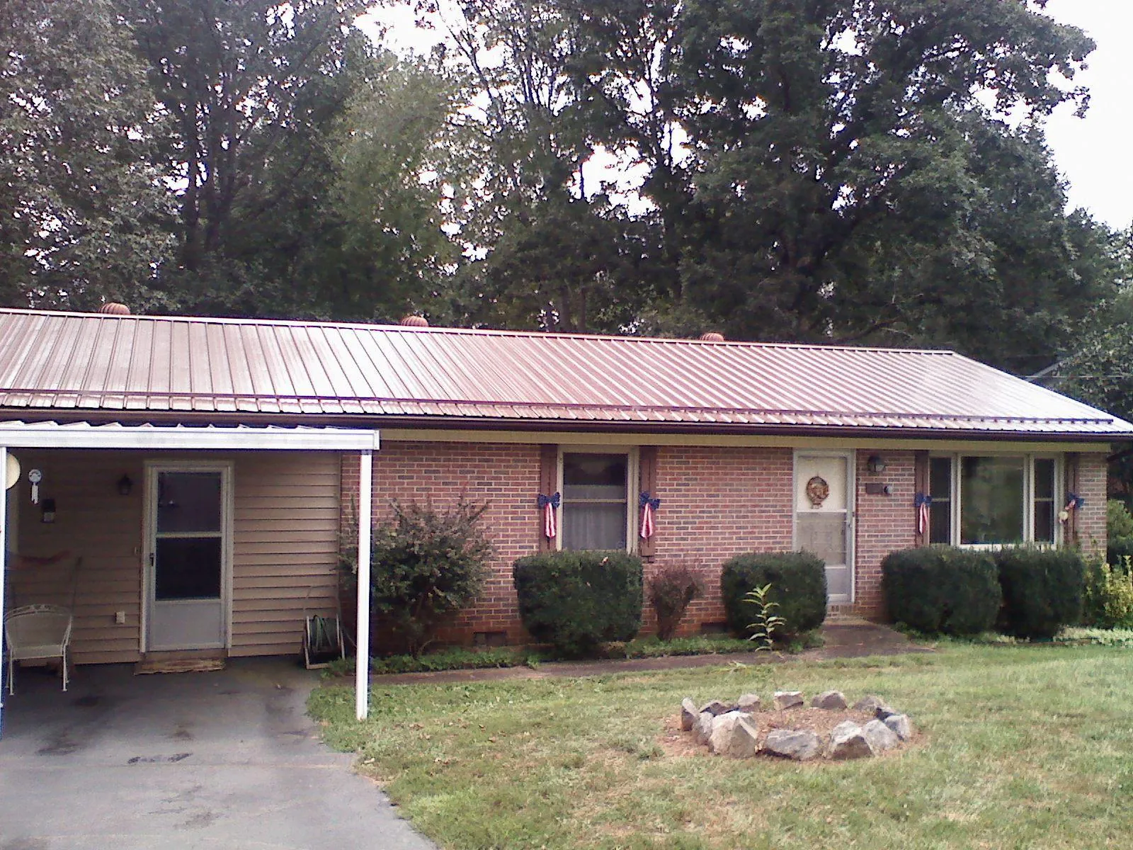 Bronze metal roof and carport on a brick ranch home — Roof Repair work by our crew in Bogart
